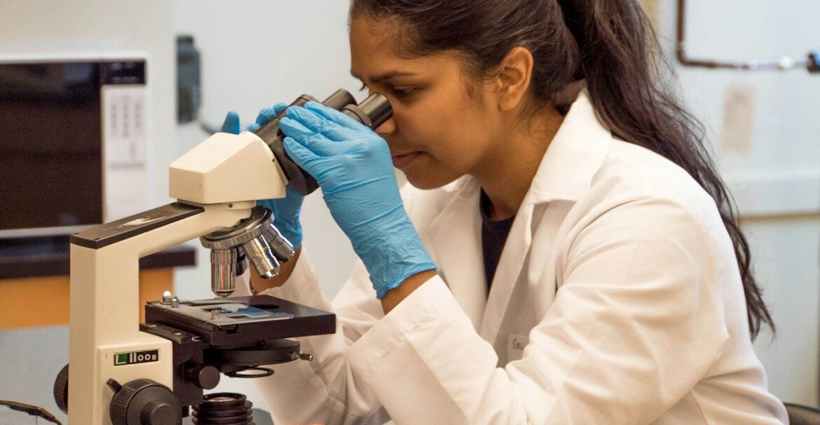 woman looking on microscope inside room