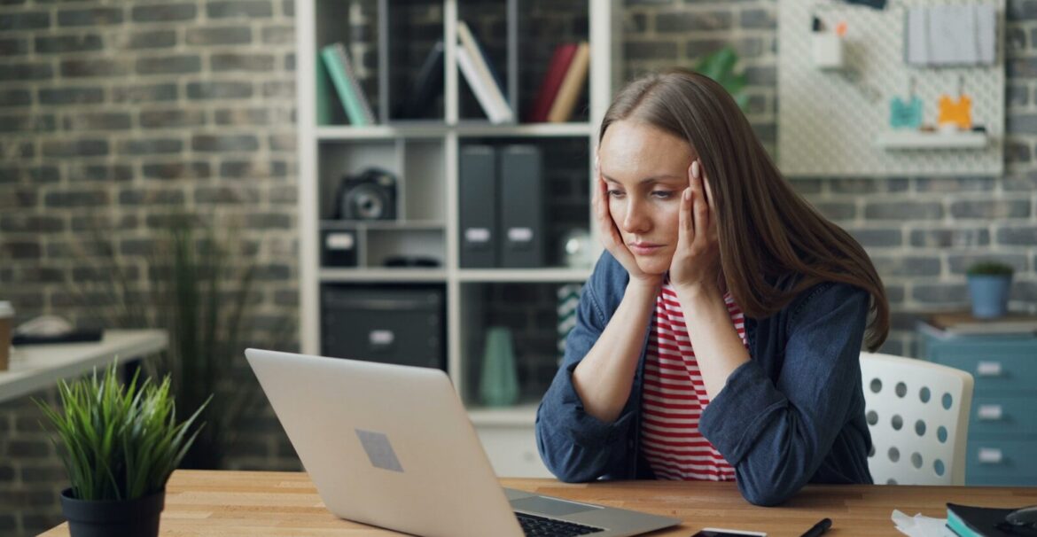 a woman sitting at a table with a laptop in front of her