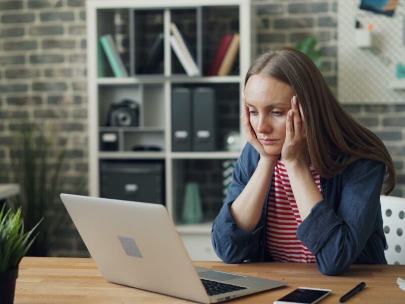 a woman sitting at a table with a laptop in front of her