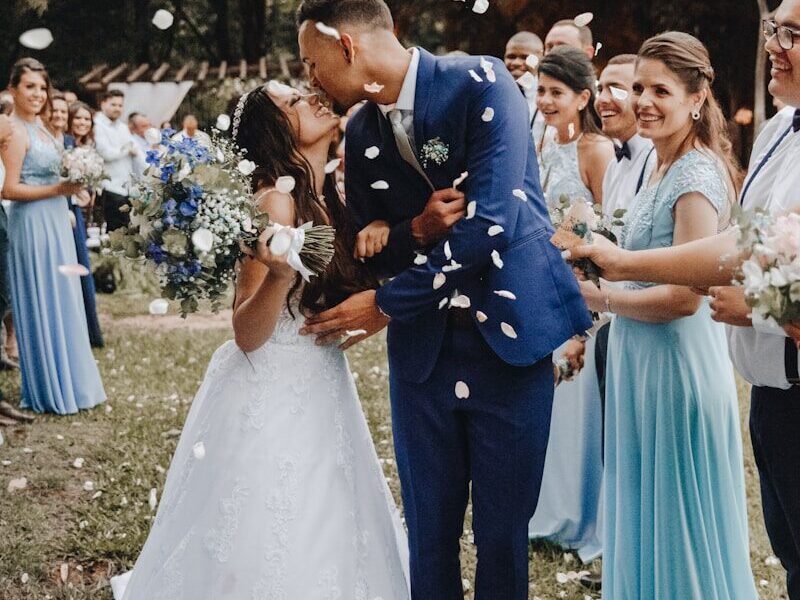 man in blue suit kissing woman in white wedding dress