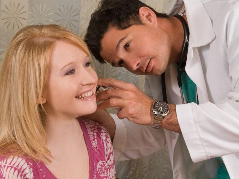 a man helping a woman get ready for a wedding