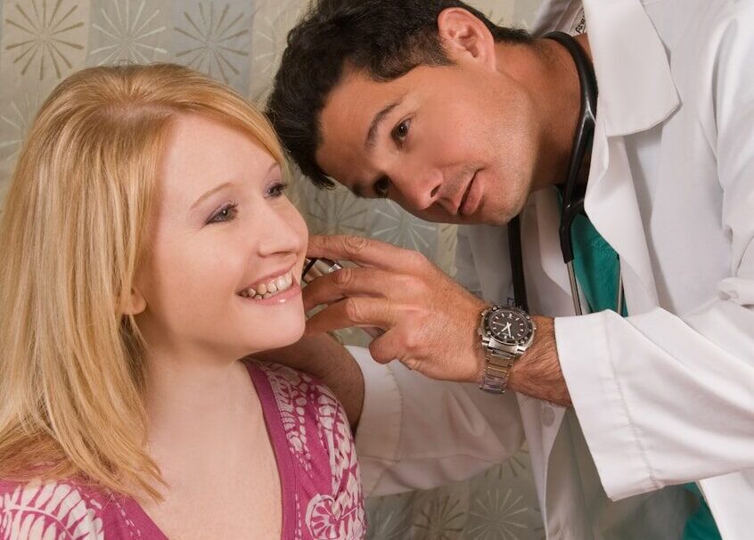 a man helping a woman get ready for a wedding