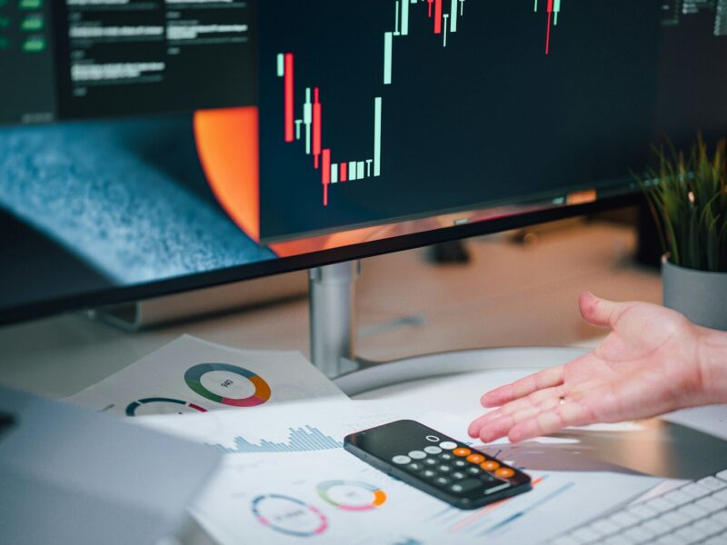 a person pointing at a calculator on a desk
