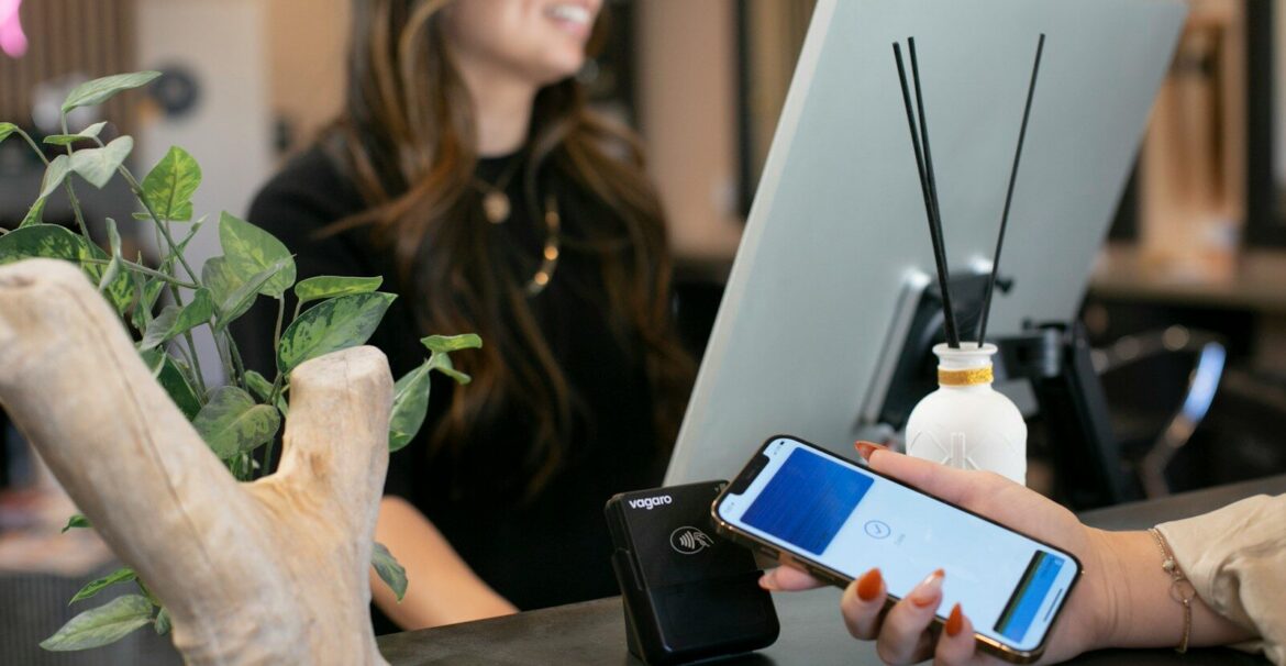 a woman sitting at a desk using a cell phone