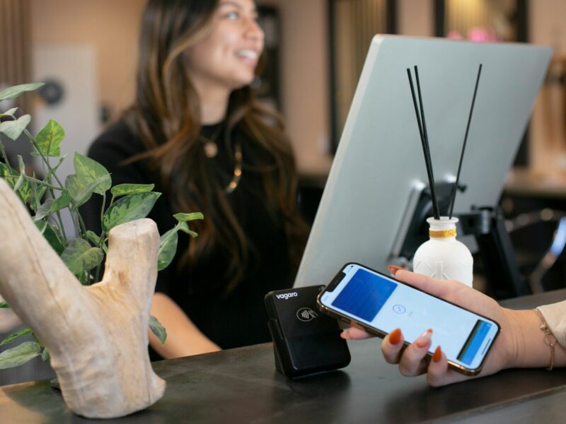 a woman sitting at a desk using a cell phone